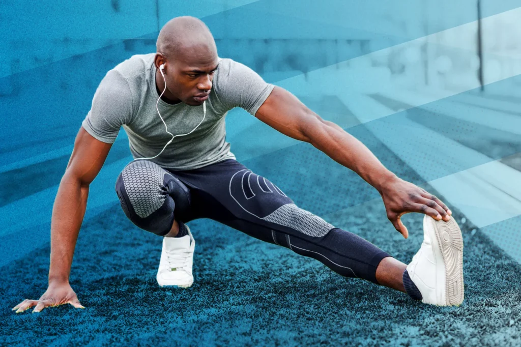 Male African American athlete stretching.