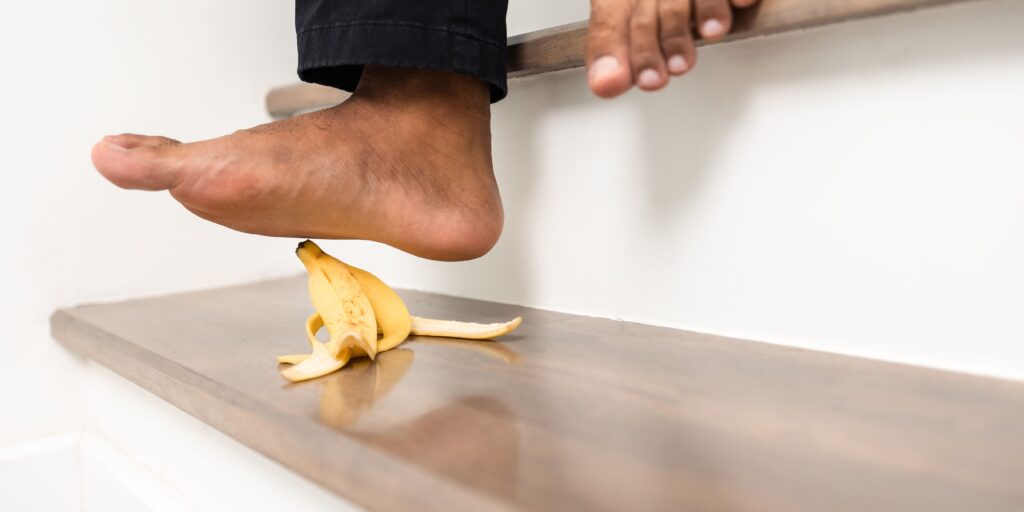 Person walking down stairs about to step on banana peel.